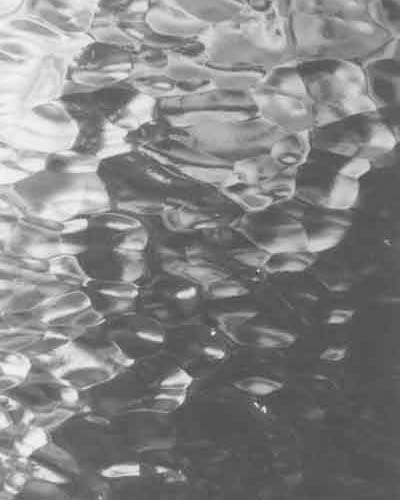 A black and white photo of water rippling in the ocean.