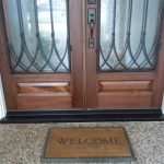 A welcome mat on the front of a door.