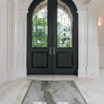 A black door with two glass panels and a marble floor.