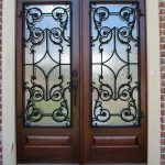 A pair of doors with wrought iron glass panels.