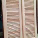 A pair of wooden shutters on the side of a door.